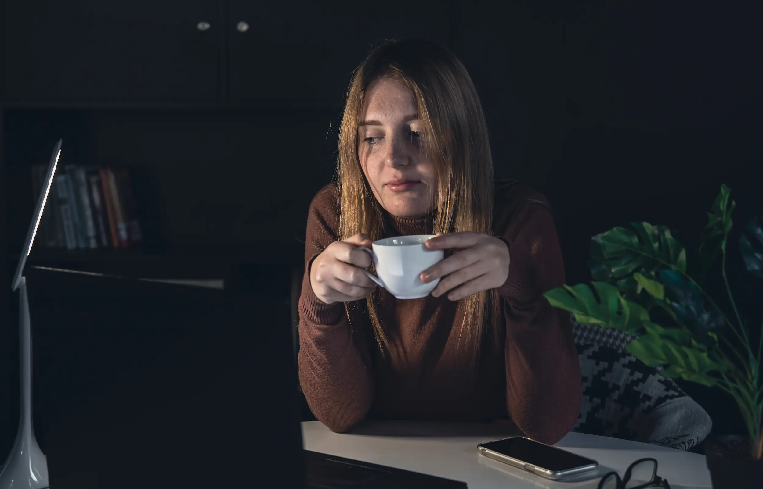 : Mulher consumindo café, ilustrando o efeito estimulante da cafeína no cérebro.